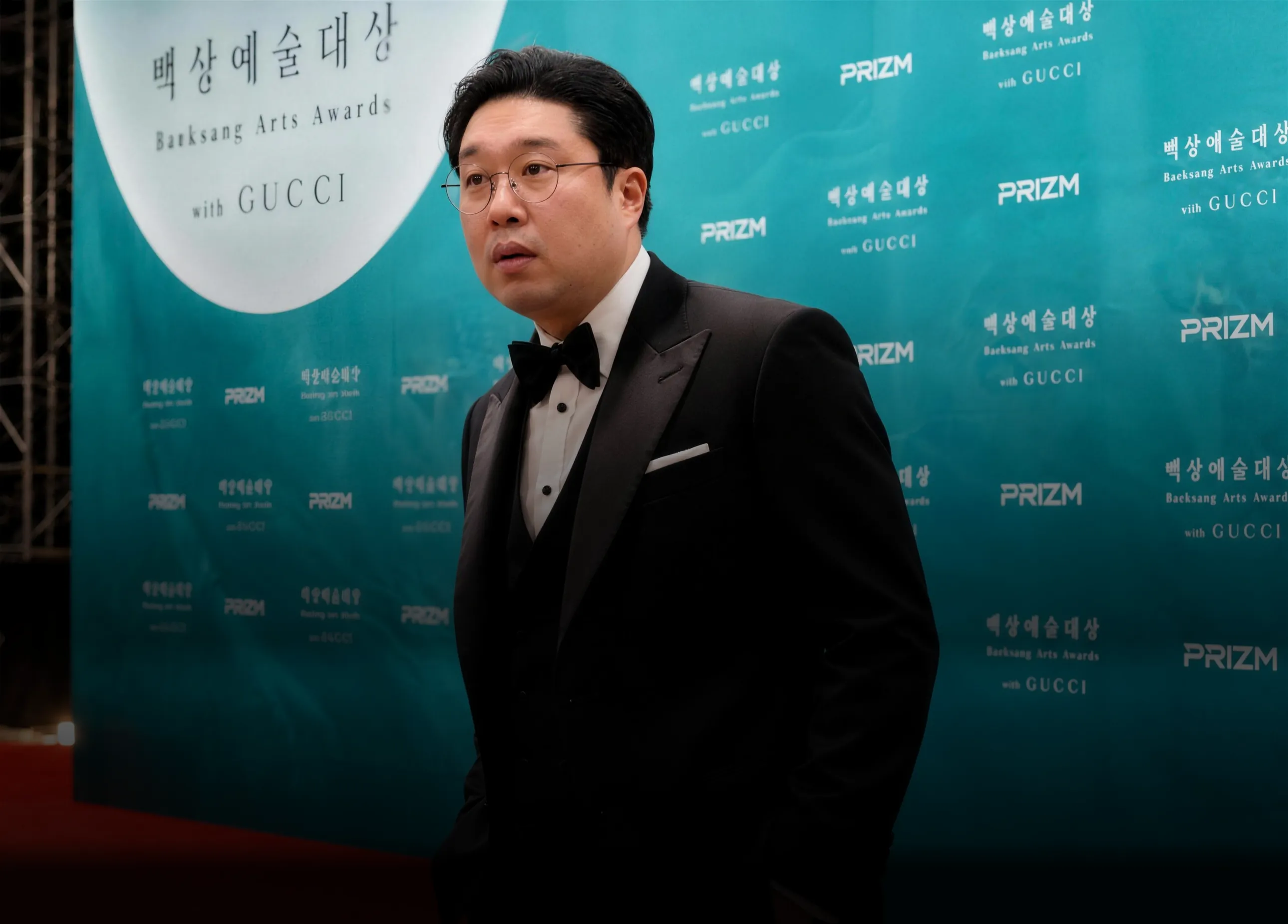 대표 강사 HUGO가 시상식 포토월 앞에 서 있다